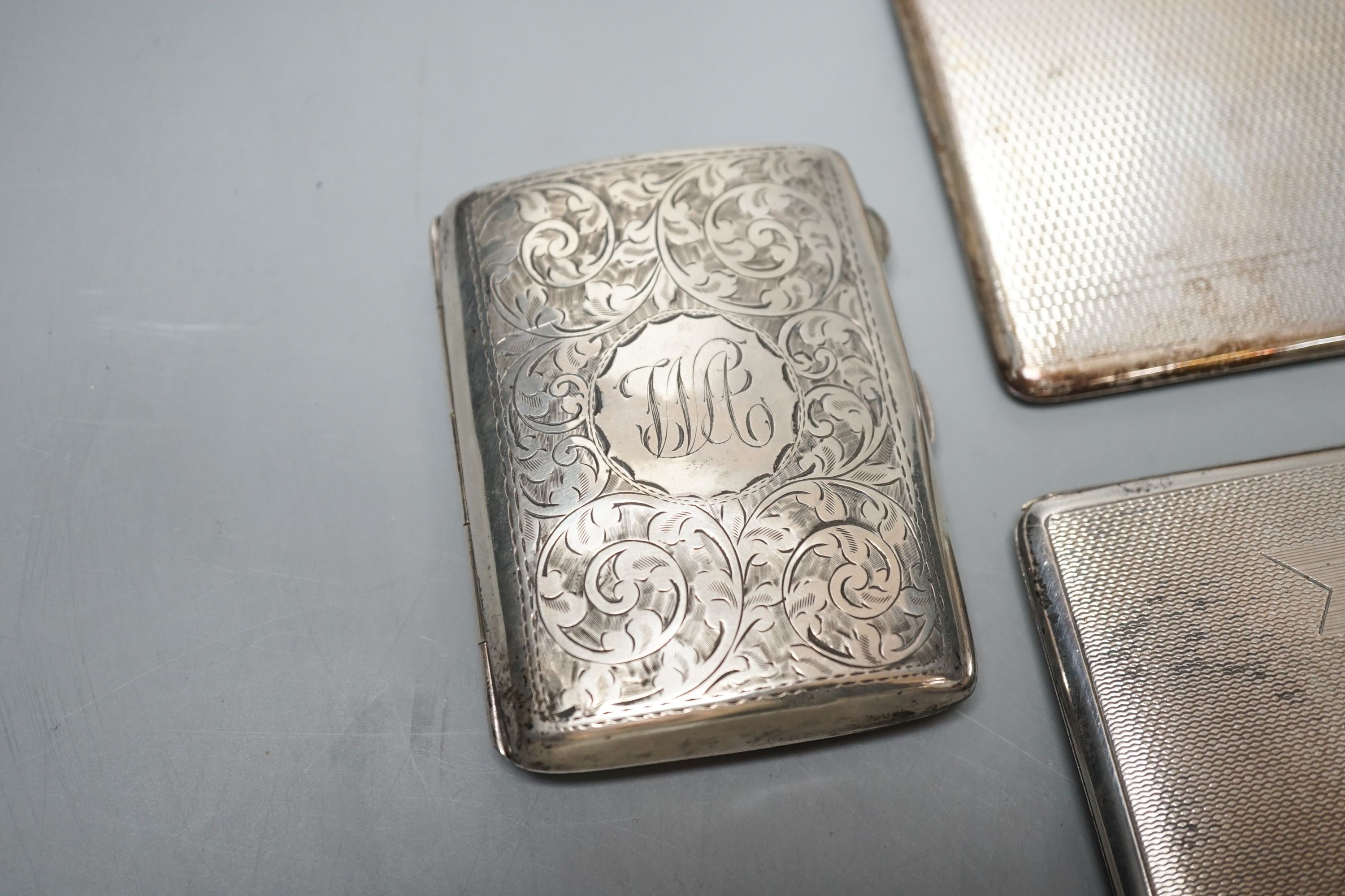 Three assorted silver cigarette cases and a silver card case, largest 14cm, gross 14oz.